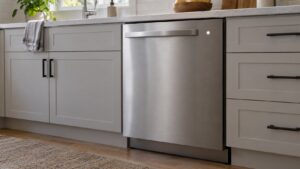 A dishwasher with its door closed and a plain cycle indicator light glowing on the control panel
